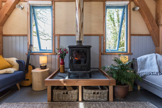 Wood-burner in living room of Carpenter Cabin with two double sofa beds