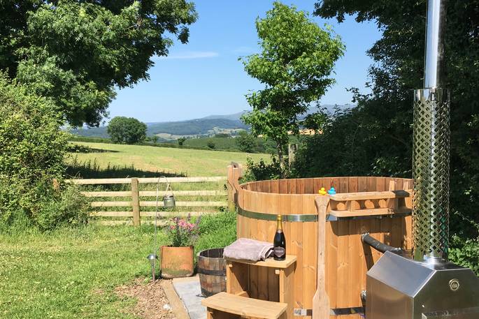 Enjoy a glass of prosecco in the wood-fired hot tub overlooking the Devon countryside at Great Links yurt
