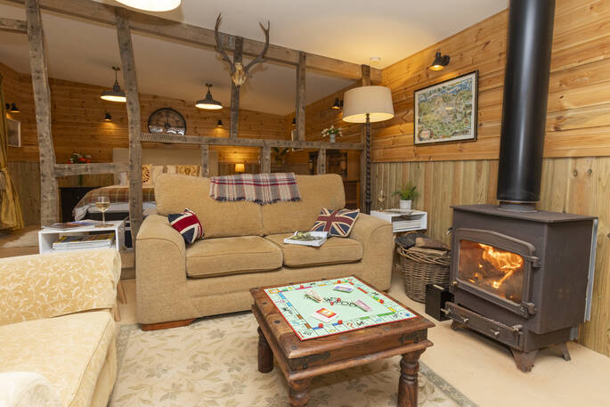 Open plan living area with a wood burner and two sofas