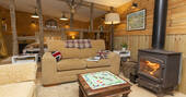 Open plan living area with a wood burner and two sofas