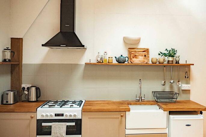 Kitchen equipped with a four ring gas hob, oven, sink and cooking utensils