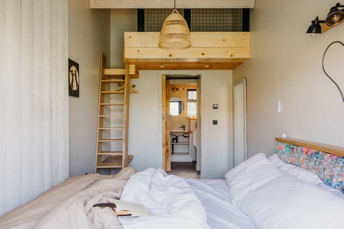 Bedroom has a small bed up on a mezzanine