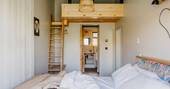 Bedroom has a small bed up on a mezzanine