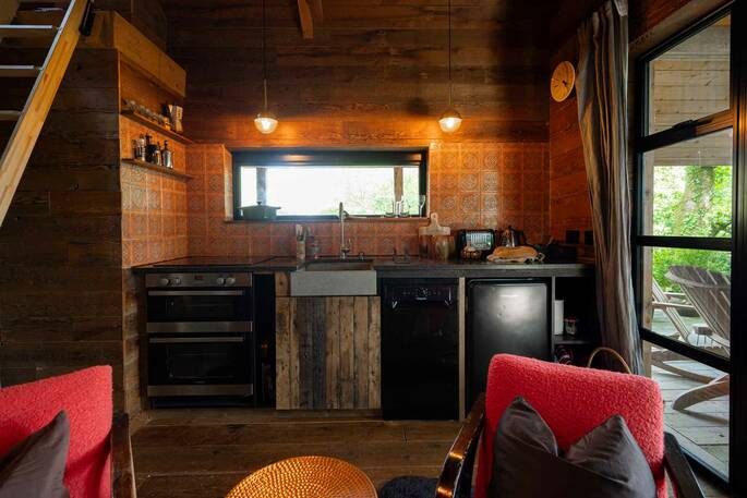 Kitchen equipped with a four-ring induction hob, kettle, toaster, oven and cooking utensils