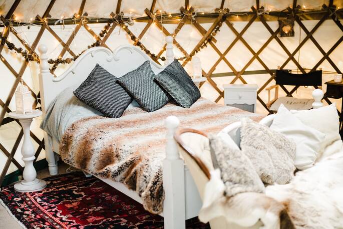 moonbeam yurt glamping holidays getaways okehampton devon england uk close up view of cosy bed on red rug