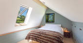 Cosy low double bed on mezzanine level in The Nap cabin at Langabridge Farm in Devon