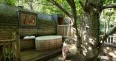 Outdoor hot tub and swing chair at Hideaway treehouse