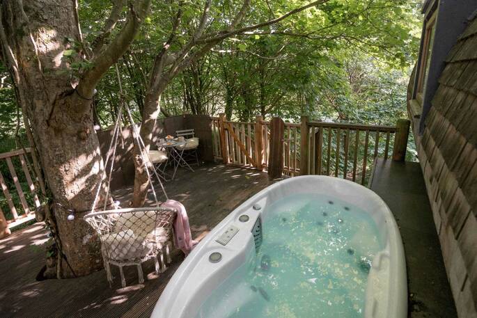 The hot tub on the deck at The Hideaway Treehouse at Pickwell Manor, Devon