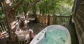 The hot tub on the deck at The Hideaway Treehouse at Pickwell Manor, Devon