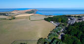 Aerial view of the sea and Pickwell Manor in Devon