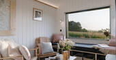 Large window in the lliving area with a view to the fields