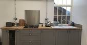 The fully equipped kitchen in the converted milking parlour at Scorlinch Shepherd's Hut, Devon
