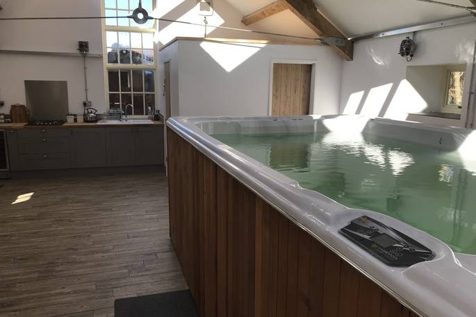 Relax in the hot tub inside the converted milking parlour at Scorlinch Shepherd's Hut