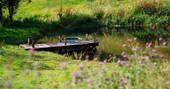 Midsummer Meadow Bed four-poster bed pond at Southcombe Barn, Dartmoor, Devon