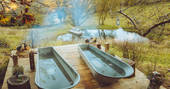The outdoor bath tubs with view to the pond at Southcombe Piggery bothy, Dartmoor, Devon