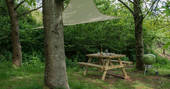 The outdoor space with canopy, picnic bench and BBQ at Fleur's Retreat in Devon