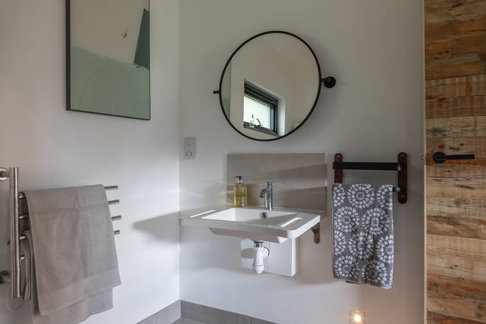 Oak Tree Cabin bathroom with a mirror, sink and towel rail