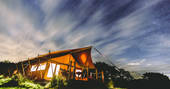 Exterior of Taw safari tent at Welcome Meadow in the night time at Devon