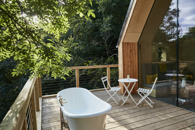 Soak in the bath tub on deck and enjoy the view looking out over the farm in Devon