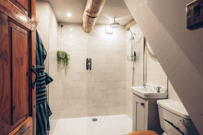 Bathroom with a hot shower, sink and flushing toilet