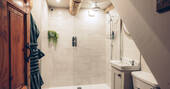 Bathroom with a hot shower, sink and flushing toilet