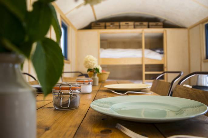 Dining table with the bunk beds in the background of Delilah the living hut at Ash Farm 