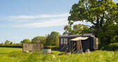 Exterior of The Happy Hare at Colber Farm in Dorset with hot tub and fire pit 