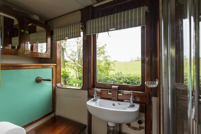 Bathroom with sink, toilet, and shower at Camping Coach in Dorset