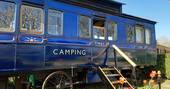 Exterior of quirky train carriage Camping Coach on the grass, Dorset