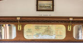 Close up of the mahogany panelling and luggage rack with a vintage railway map at Camping Coach, Dorset