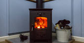 A cosy fire burning in the log burner inside Laverstock's Everdene Hut, Dorset