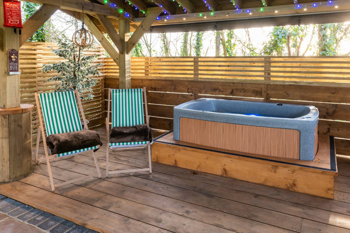 Hot tub on the decking next to Bluebell the shepherd's hut at The Wright Retreat in Gloucestershire