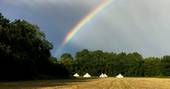 Rainbow over the camp at Mundays Meadow in Gloucestershire