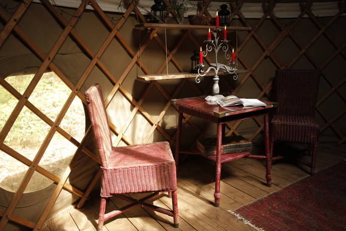 Table and chairs inside Birch yurt at Adhurst, Hampshire