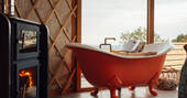 Free standing bath tub in the yurts next to the wood burner
