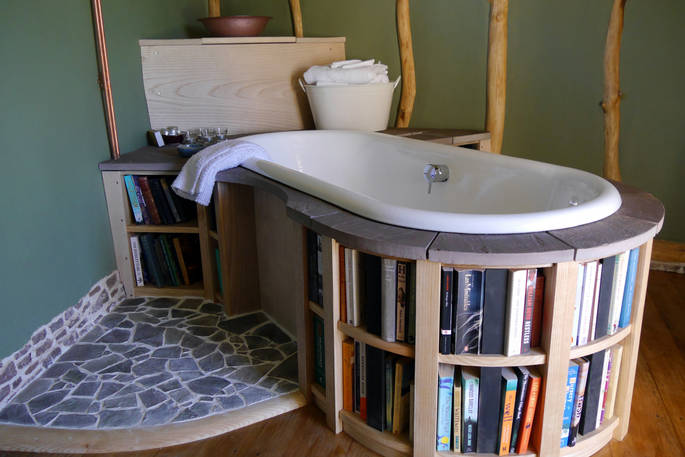 Soak in the bathtub surrounded by books in The DugOut's library bathroom