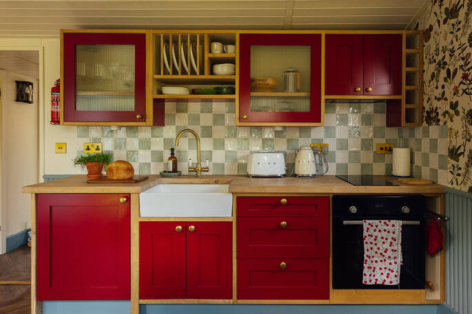 Kitchen equipped with an oven, induction hob, kettle, toaster and cooking utensils, crockery and glassware
