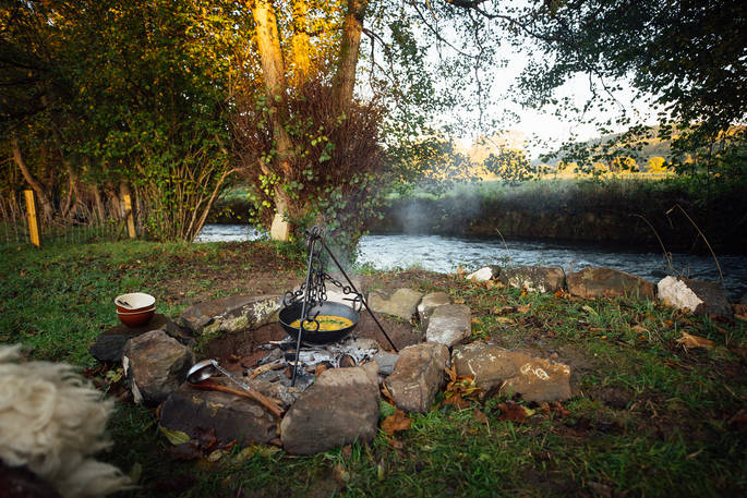 Millie the Hut shepherd's hut cooking by the river, Wegnalls Mill, Presteigne, Herefordshire - Owen Howells Photography