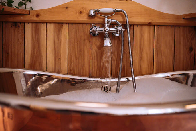 Bathroom with roll top bath tub, sink and flushing toilet