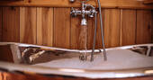 Bathroom with roll top bath tub, sink and flushing toilet