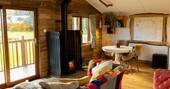 Open plan living area with sofa, and wood burner