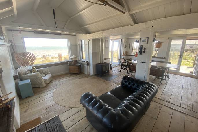The Beach House cabin living room with view to the sea, Isle of Sheppey, Kent, England