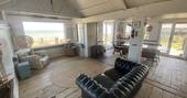 The Beach House cabin living room with view to the sea, Isle of Sheppey, Kent, England
