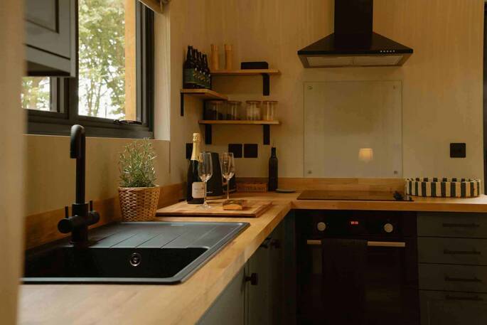 Kitchen equipped with a four-ring gas hob, kettle, and cooking utensils
