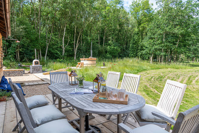 The spacious outdoor seating area with views of the hot-tub, gardens and pizza oven at Knotting Hill Barn in Leicestershire