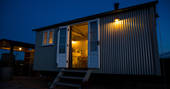 Exterior of Justin, the shepherd’s hut, in the evening at Tin and Wood