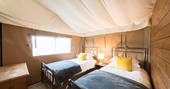 Two single beds inside your safari tent at The Nest in Lincolnshire