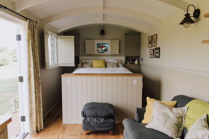 King-size bed inside Cowslip shepherd's hut at Honey Pot Meadow at Wild With Nature