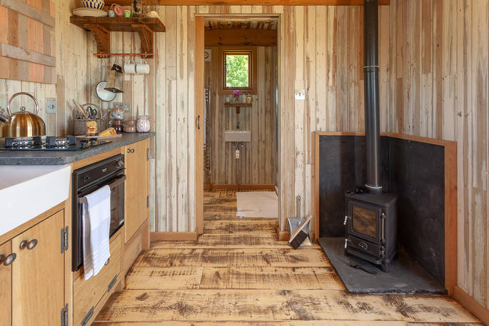 Sit by the wood-burner inside Dunmore at Huts in the Hills in Northumberland