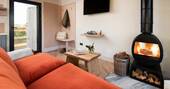 Howlet living area with a sofa and wood burner